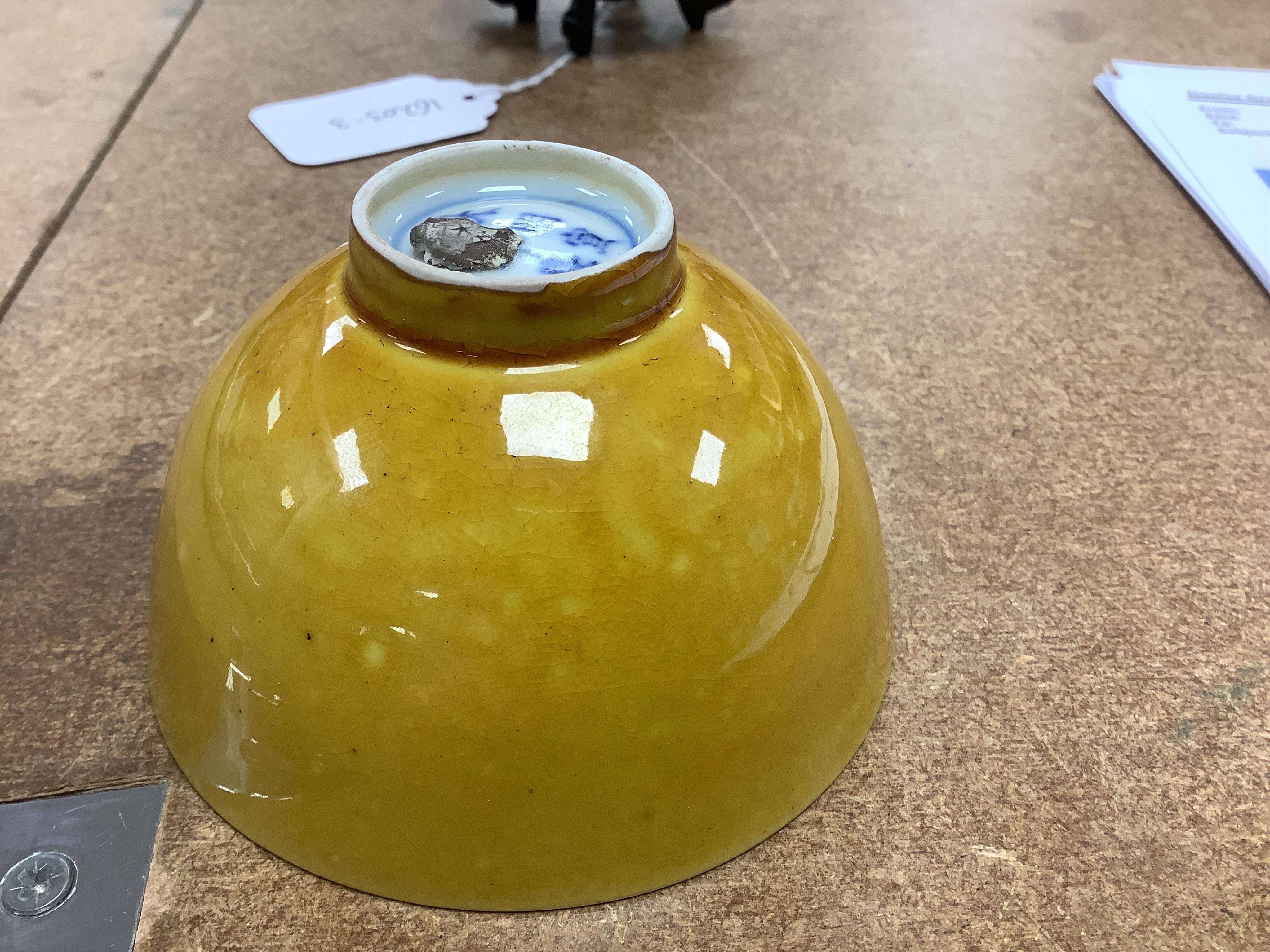 A Chinese yellow glazed teabowl on hardwood stand, 9cm diameter. Condition - fair